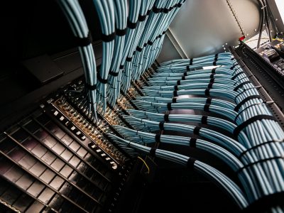 A close-up view of blue network cables neatly arranged in a data center rack, illustrating modern connectivity and efficient IT infrastructure management.